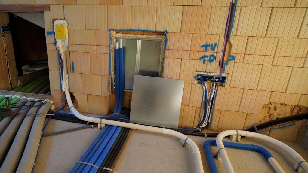 Fase di installazione in cantiere del sistema a scomparsa Retraflex: posa della tubazione rigida sotto traccia per impianto di aspirazione centralizzata.